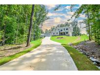 A charming two-story home nestled on a wooded lot with a long driveway at 2201 E Maddox Rd, Buford, GA 30519