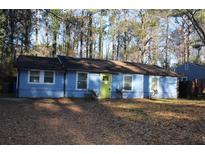 Ranch style home with blue siding, green door and mature trees at 1026 Valley View Rd, Atlanta, GA 30315