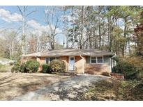 Brick ranch home with a tree-lined yard and driveway at 2576 Wood Valley Dr, Atlanta, GA 30344