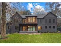Stunning two-story home with gray siding and a manicured lawn at 1240 Spalding Dr, Sandy Springs, GA 30350