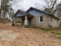 Brick ranch house with covered porch and mature trees at 4451 Flat Shoals Pkwy, Decatur, GA 30034