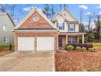 Brick two-story house with a two-car garage and landscaping at 2070 Bonny Glen Cir, Austell, GA 30106