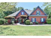 Brick house with landscaped lawn and walkway at 7020 Grassmoor Grange Way, Cumming, GA 30040