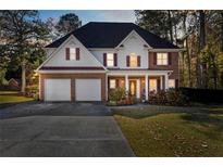 Two-story brick home with a three-car garage and landscaped yard at 4844 Dartford Dr, Powder Springs, GA 30127