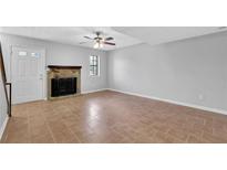Bright living room with tile floors, fireplace, and ceiling fan at 731 Victoria Sw Pl, Atlanta, GA 30310