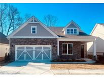 Brick and shingle two-story house with a two-car garage and landscaped yard at 7125 Winderlea Ln, Cumming, GA 30040