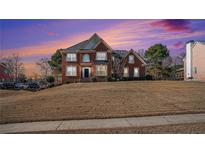 Brick two-story house with a landscaped yard at dusk at 104 Lumby Ln, Stockbridge, GA 30281