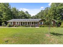 Brick ranch house with a large yard and mature trees at 1051 Rock Springs Rd, Lawrenceville, GA 30043