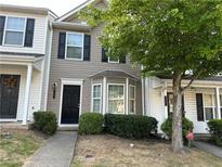 Two-story townhome with gray siding, black shutters, and landscaping at 837 Crestwell Sw Cir, Atlanta, GA 30331