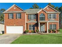 Brick two-story house with a white garage door and a well-maintained lawn at 3736 Busker Mill Ln, Ellenwood, GA 30294
