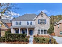 Two-story brick home with blue shutters and a welcoming front porch at 20 Daniel Creek Ln, Sugar Hill, GA 30518