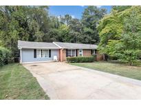Brick ranch home with a gray accent, driveway, and landscaped lawn at 3569 Briar Dr, Lithia Springs, GA 30122