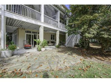 Large stone patio with access to a screened porch and stairs at 614 E Cooper Ave, Folly Beach, SC 29439