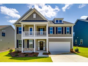 Two-story home with white garage door and balcony at 4045 Rowley Lane, Summerville, SC 29486