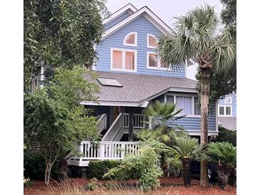 Two-story light blue house with white trim and a deck at 2221 Oyster Catcher Ct, Seabrook Island, SC 29455