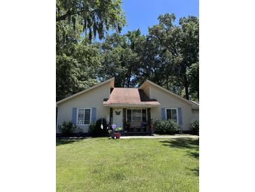 Cute yellow house with blue shutters and a well-maintained lawn at 106 Teddy Ct, Summerville, SC 29485