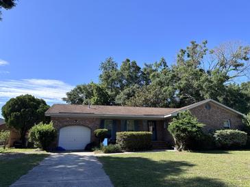 Brick ranch home with attached garage and landscaped yard at 1219 Oakcrest Dr, Charleston, SC 29412