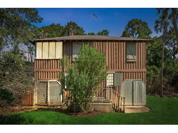 Rustic two-story home with wood siding and small deck at 712 W Ashley Ave, Folly Beach, SC 29439
