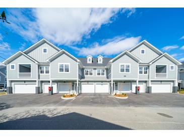 Gray siding townhomes with attached garages and landscaping at 420 Carolina Cherry Ct # 201, Charleston, SC 29414