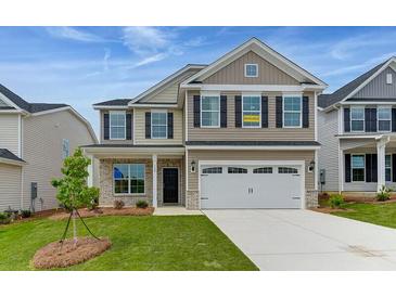 Two-story beige house with a large white garage door and a landscaped lawn at 115 Ashley Cove Way, Summerville, SC 29483