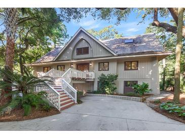 A charming two-story home with a large front porch and a lush green lawn at 202 Needlerush Rd, Kiawah Island, SC 29455