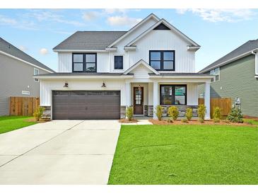 Two story farmhouse style home with white siding and dark accents at 537 Rendezvous Way, Huger, SC 29450