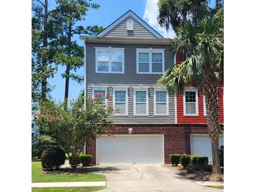 Two-story townhome with gray and red siding, two-car garage, and landscaping at 9120 Parlor Dr, Ladson, SC 29456