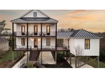 Two-story home with dark metal roof, white siding, and elevated foundation at 66 Cooper St, Charleston, SC 29403