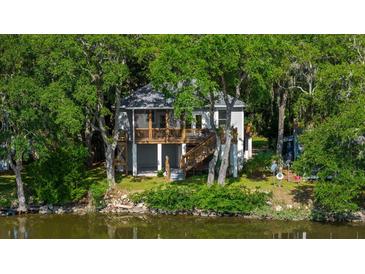 Elevated home on waterfront property with lush green surroundings at 8541 Oyster Factory Rd, Edisto Island, SC 29438