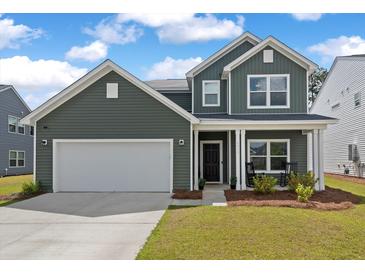 Two story green house with rocking chairs on the porch at 4413 Palm Shadow Dr, Summerville, SC 29485