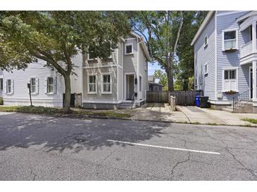 Gray three-story home with driveway and mature trees in front at 291 Coming St, Charleston, SC 29403