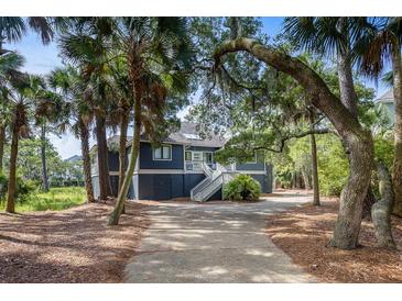 Dark blue home nestled amongst lush trees and landscaping at 2963 Deer Point Dr, Seabrook Island, SC 29455