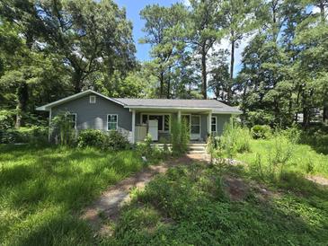 Gray house with overgrown yard needing landscaping at 436 W Butternut Rd, Summerville, SC 29483