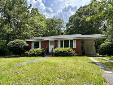 Brick ranch home with a covered carport and well-maintained lawn at 2751 Mawood Ave, North Charleston, SC 29406