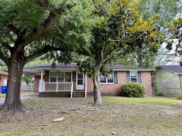 Brick home with mature trees and a white porch at 4750 Linda St, North Charleston, SC 29405