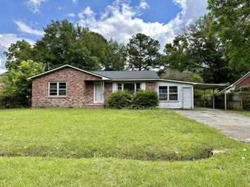 Brick ranch home with carport and spacious lawn at 7070 N Kenwood Dr, North Charleston, SC 29406