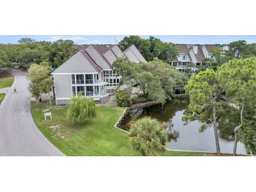 Aerial view of waterfront property with houses and a pond at 202 Mariners Cay Dr, Folly Beach, SC 29439