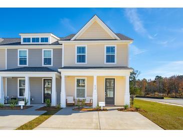 Two-story tan and gray townhome with a front porch and two-car driveway at 229 Abercom Place Dr, Moncks Corner, SC 29461