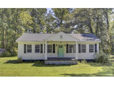 Charming white cottage with a light green door and black shutters at 1586 Highway 15, Saint George, SC 29477