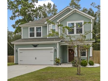 Two-story house with green siding, white garage door, and landscaping at 316 Bay Village Ln, Moncks Corner, SC 29461