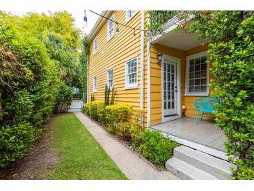 Charming yellow house with a side yard and small patio at 167 Coming St, Charleston, SC 29403