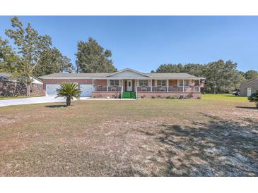 Brick ranch house with attached garage, covered porch, and landscaped yard at 1090 Peru Rd, Saint Stephen, SC 29479