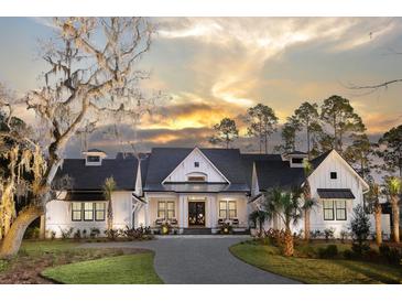 Stunning white farmhouse exterior with a black roof, large windows, and a paved driveway at Lot 93 Lady Banks Ln, Hollywood, SC 29470