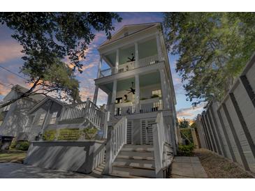 Tall white house with light teal accents, multiple porches, and a gray stone wall at 413 King St, Mount Pleasant, SC 29464
