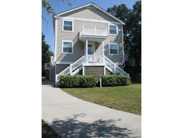 Two story house with light beige siding, white trim, and a front porch at 32 41St Ave, Isle of Palms, SC 29451