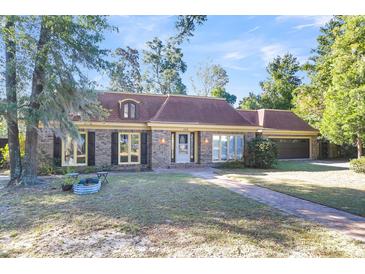 Brick home with brown roof, landscaped lawn, and a paved walkway at 428 Carn St, Walterboro, SC 29488