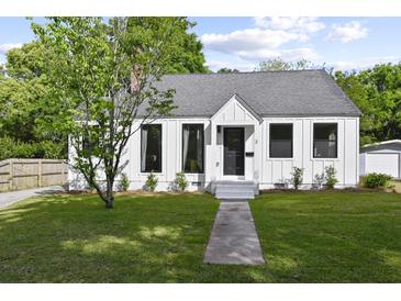Charming white farmhouse with gray roof, landscaping, and walkway at 3 Penn Ave, Charleston, SC 29407