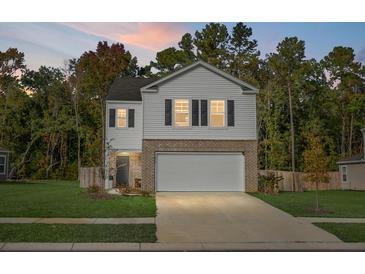 Two story house with white siding, brick bottom, and two car garage at 370 Spruce Ivy St, Moncks Corner, SC 29461