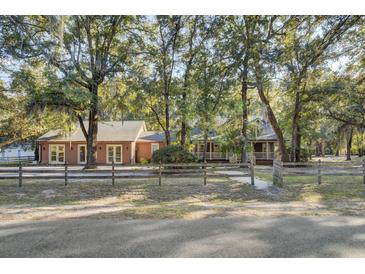 Two-story home with a wraparound porch and mature trees at 4429 Francis Younge Way, Hollywood, SC 29449