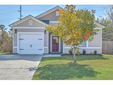 One-story house with attached garage and a colorful tree in front at 120 Deerpath Trl, Summerville, SC 29486